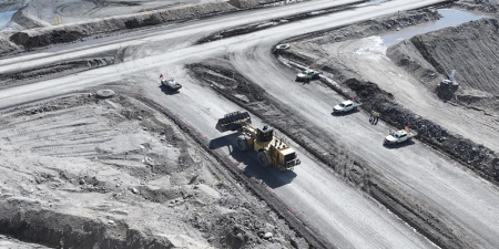 front-end loader approaching a light vehicle from behind at an intersection at an open-cut coal mine